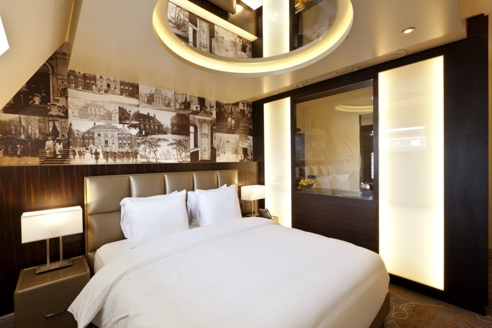 Ruime slaapkamer met ronde spiegel boven bed